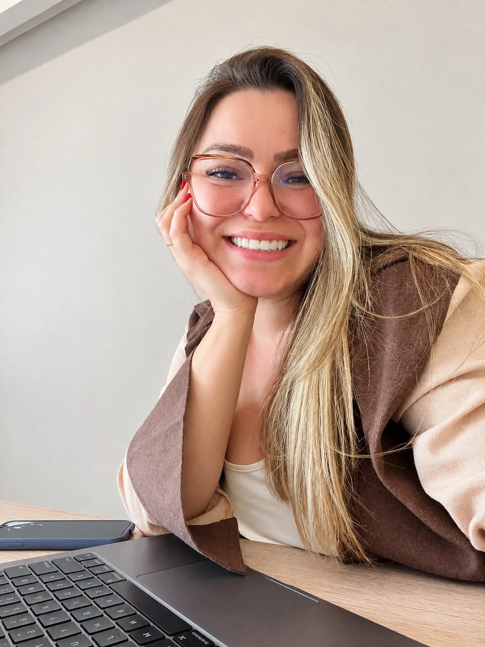 Natália, fundadora da Elev, sorrindo à mesa de trabalho